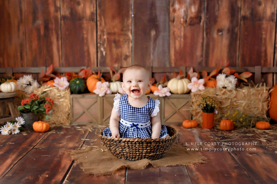 baby photographer near Austell, girl in basket for fall theme milestone session
