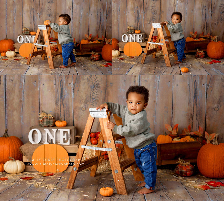baby photographer near Newnan, one year old boy standing by ladder during fall session
