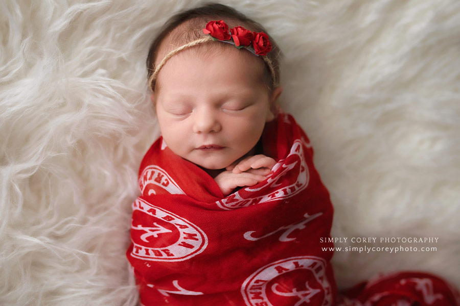 newborn photographer near Carrollton, GA; baby girl in Alabama football wrap