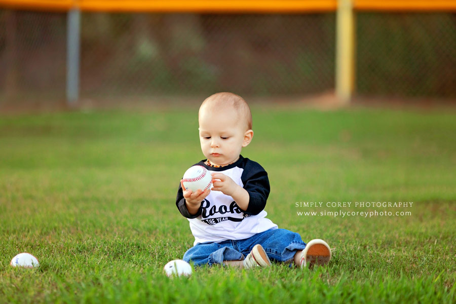 baby photographer near Carrollton, Georgia; boy sitting on field with baseballs