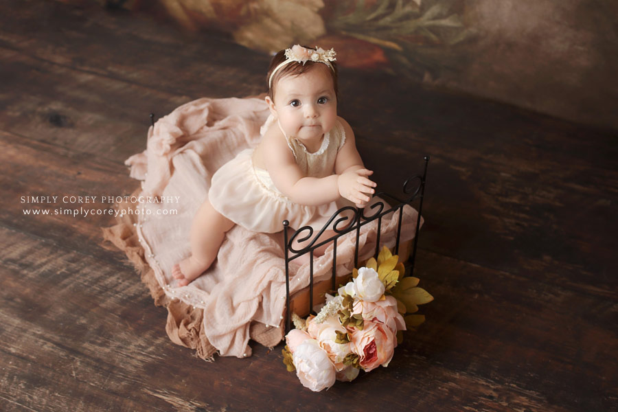 Newnan baby photographer, girl on little bed during studio portrait session