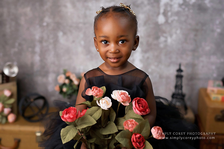 Carrollton baby photographer, girl in black dress holding flowers