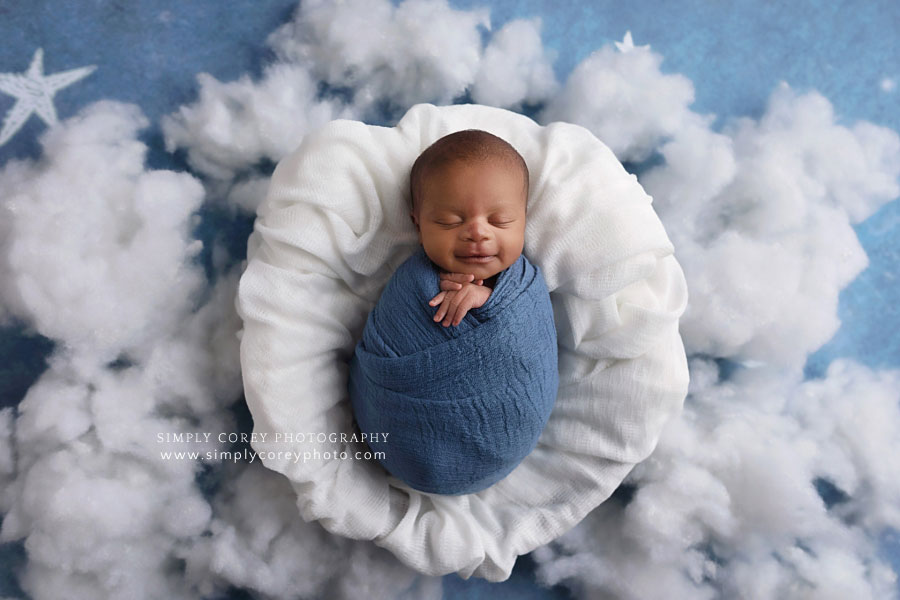Atlanta newborn photographer, baby boy smiling in blue with clouds