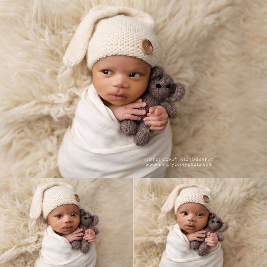 West Georgia newborn photographer, baby with a funny expression holding a bear 