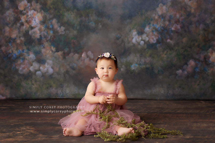 baby photographer near Peachtree City, girl in tulle dress with floral backdrop in studio