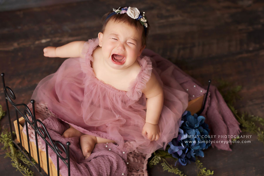 West Georgia baby photographer, girl crying on bed during studio session