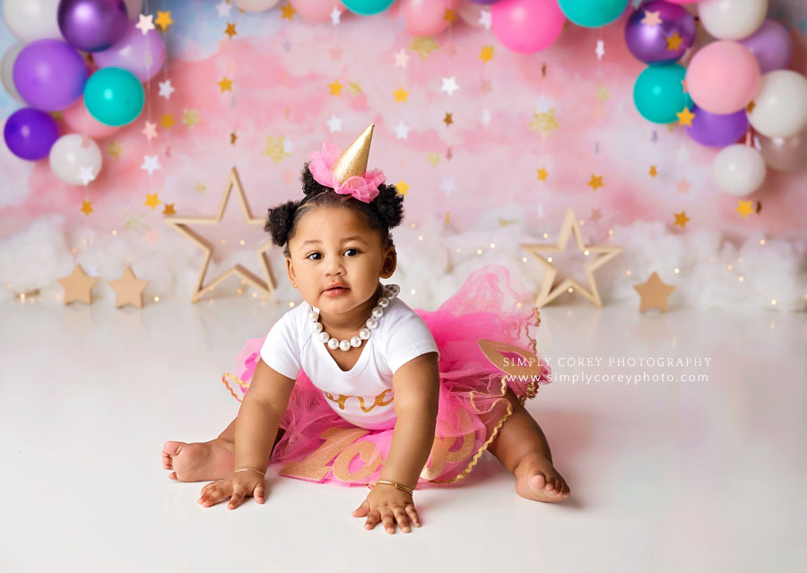 baby photographer near Peachtree City, girl in party hat and tutu with stars and balloon garland