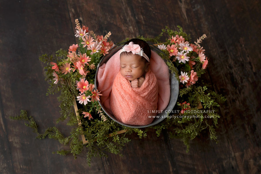 newborn photographer near Carrollton, GA; baby girl in coral wrap with flowers