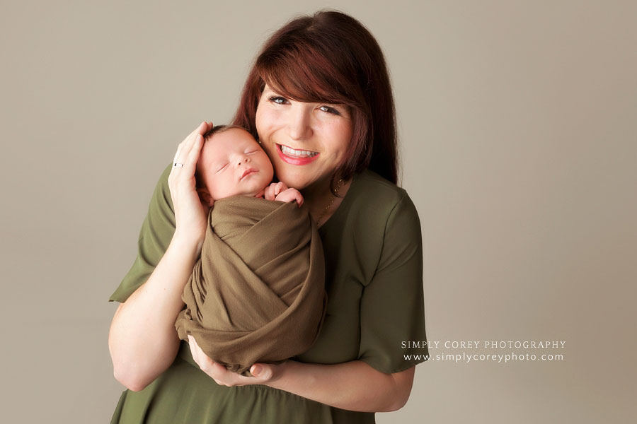 Atlanta newborn photographer, mom holding new baby boy in studio