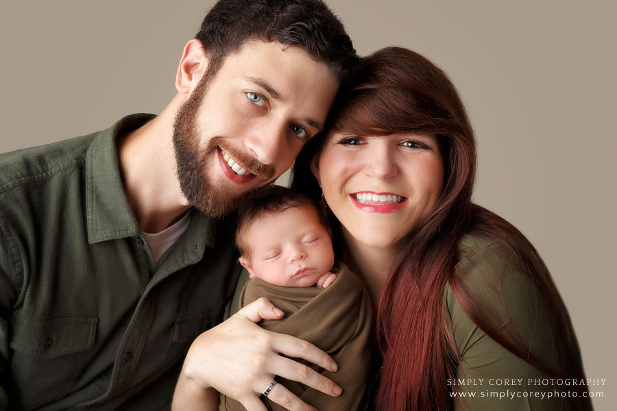 Carrollton family photographer in Georgia, parents with newborn baby in green