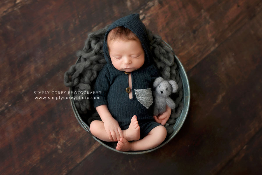 Douglasville newborn photographer, baby boy in hooded outfit in a bucket with a bear