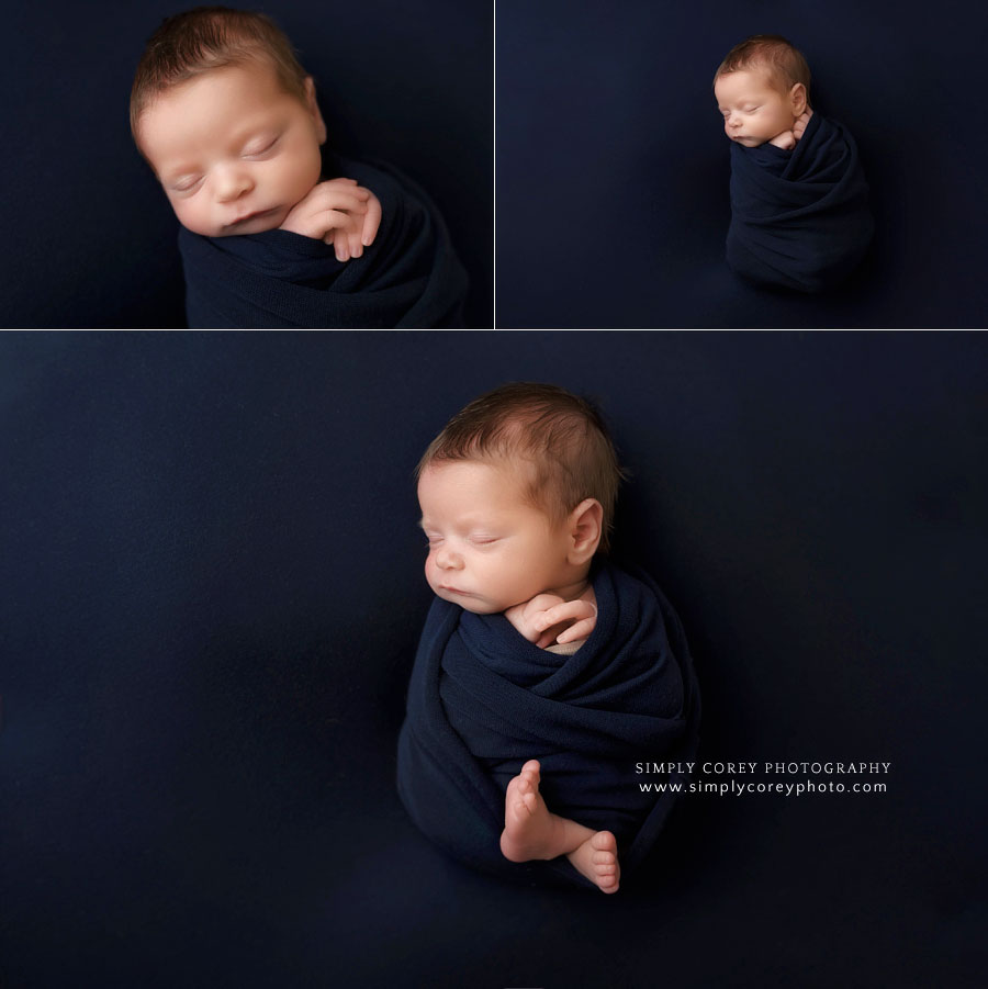 newborn photographer near Carrollton, GA; baby boy with navy blue swaddle and backdrop