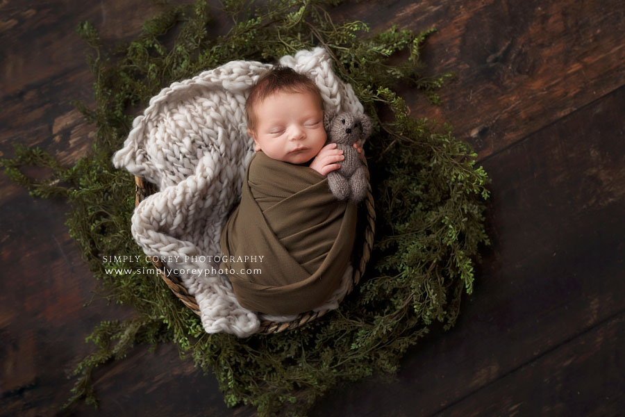 Newnan newborn photographer, baby boy in green holding teddy bear