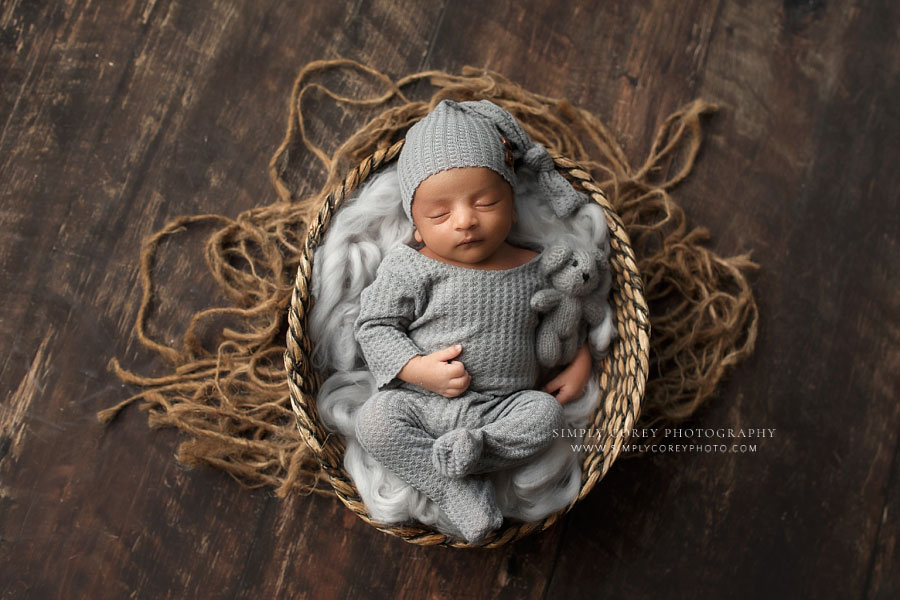 newborn photographer near Carrollton, GA; baby boy in gray pajamas and basket