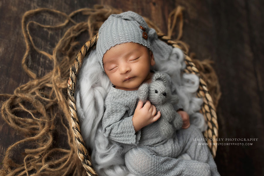 newborn photographer near Villa Rica, baby boy in gray sleeper with teddy bear