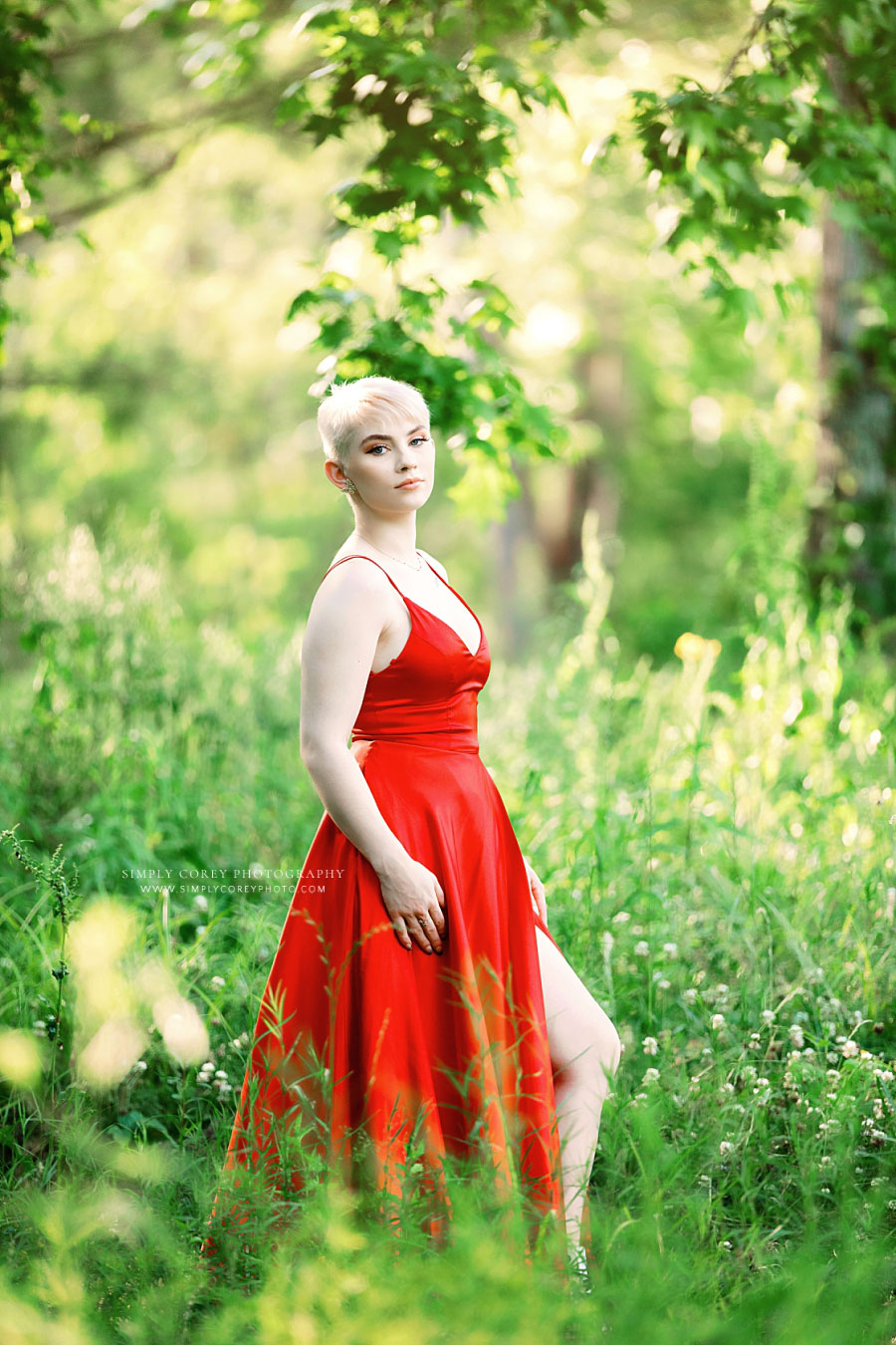 senior portrait photographer near Atlanta, teen with pixie cut in red formal dress outside