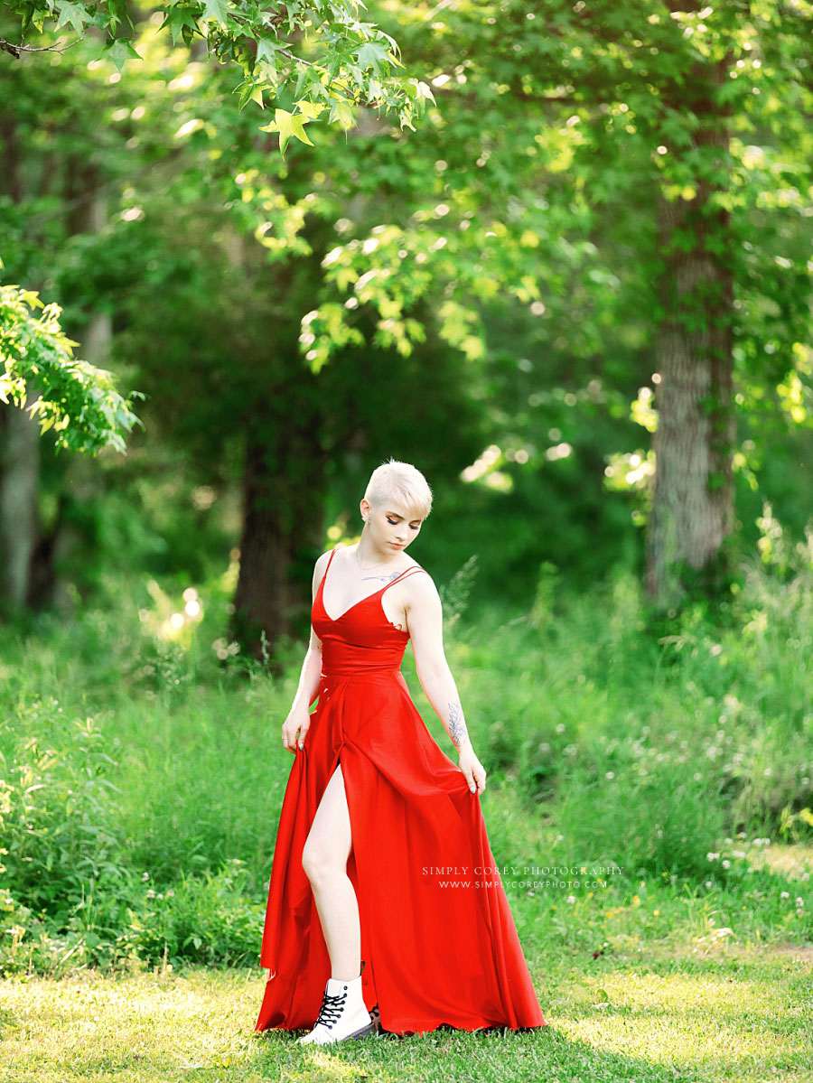 senior portrait photographer near Villa Rica, teen in red formal dress outside in field