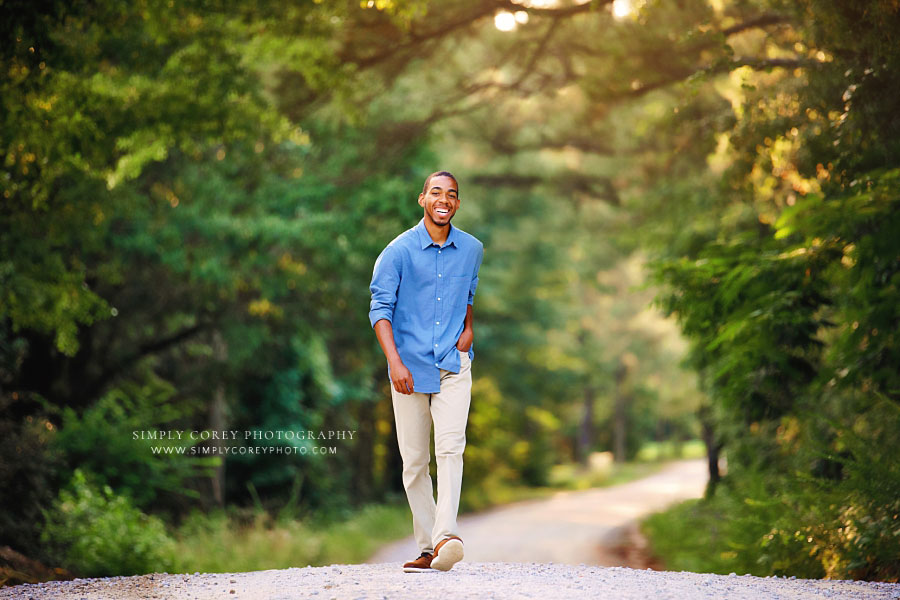 senior portrait photographer near Atlanta, smiling teen boy walking on country road
