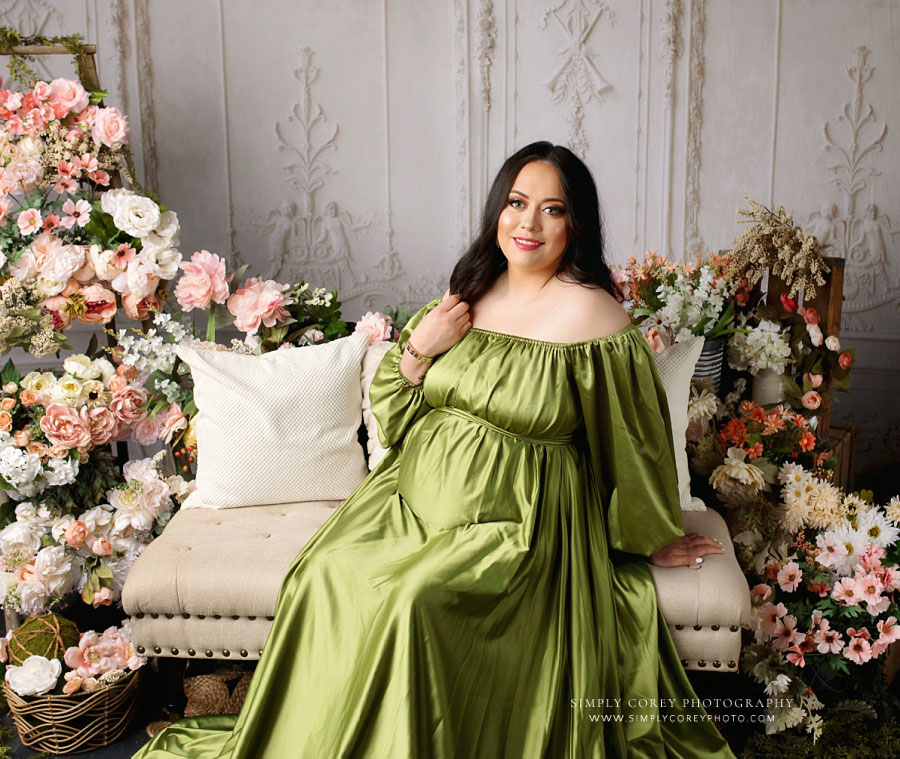 maternity photographer near Atlanta, mom sitting in green dress with flowers in studio