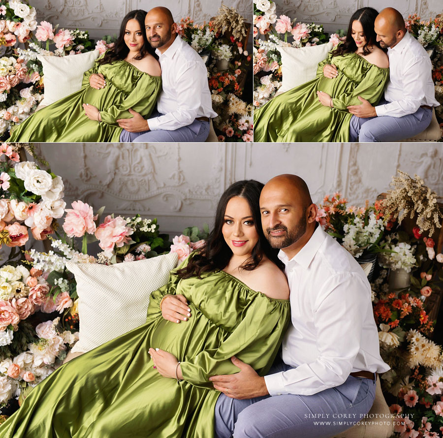 Newnan maternity photographer, mom in green dress with dad near flowers in studio