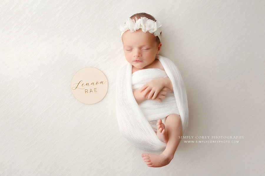Carrollton newborn photographer in Georgia, baby girl in white with wooden name plate