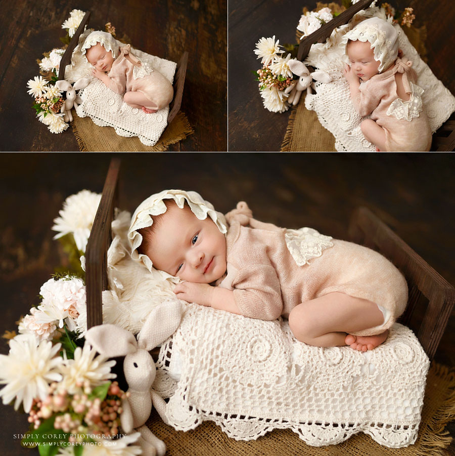Hiram newborn photographer, baby girl in pink outfit on small bed with flowers