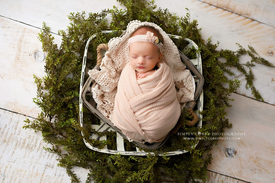 newborn photographer near Hiram, baby girl in pink with baskets and greenery