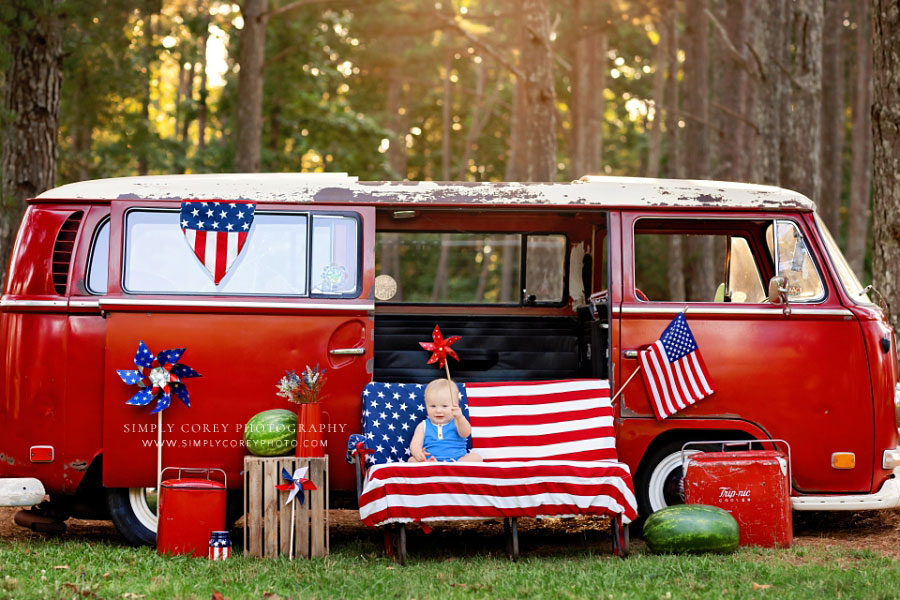 mini session photographer near Hiram, baby on American flag bench with red VW bus