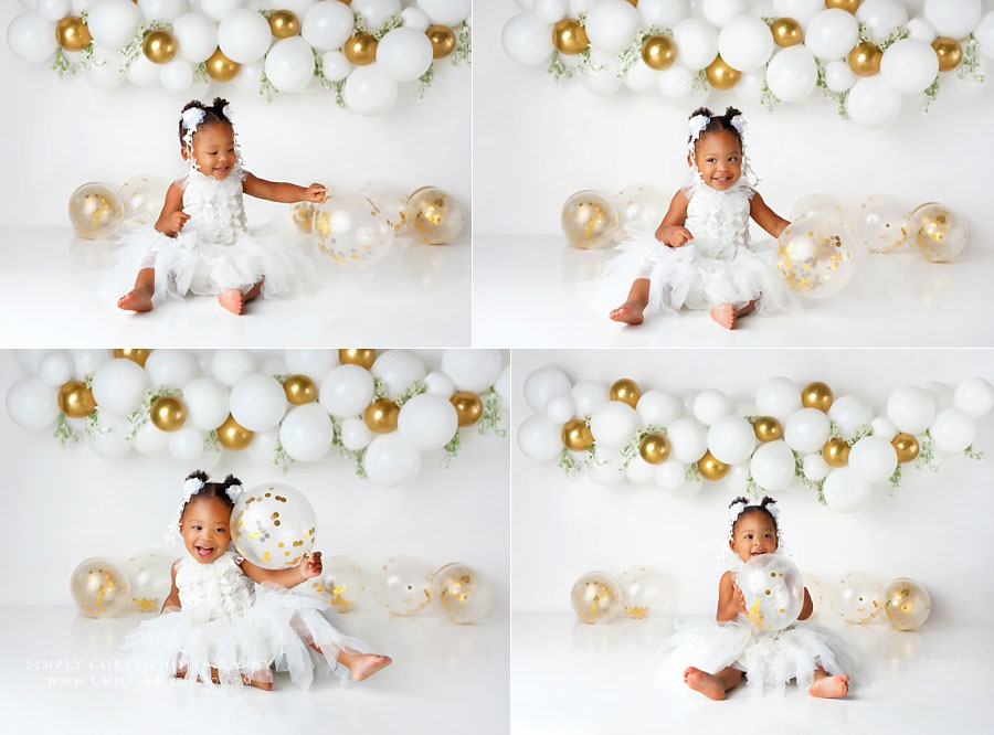 baby photographer near Lithia Springs, one year old girl playing with balloons during studio session