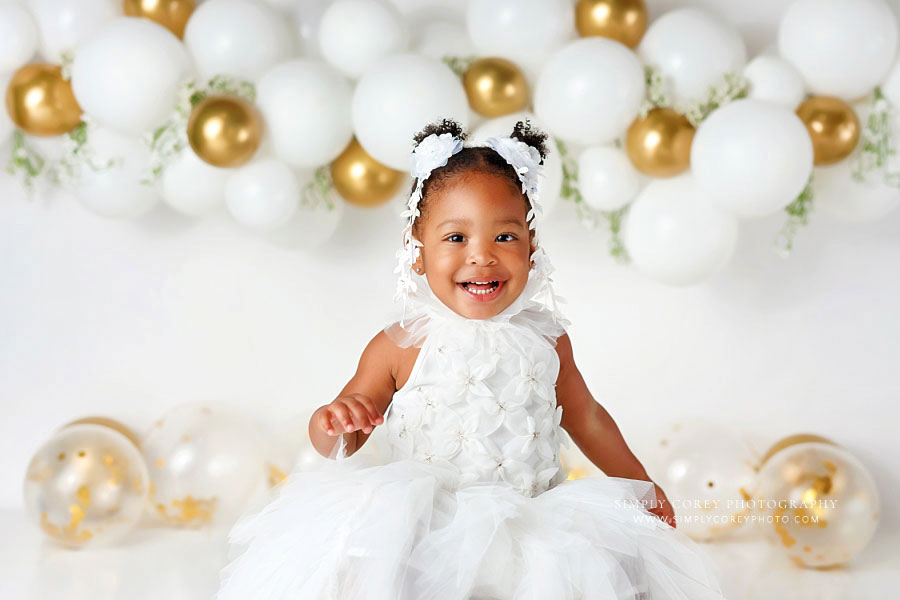 baby photographer near Newnan, girl with white and gold balloon garland for milestone session