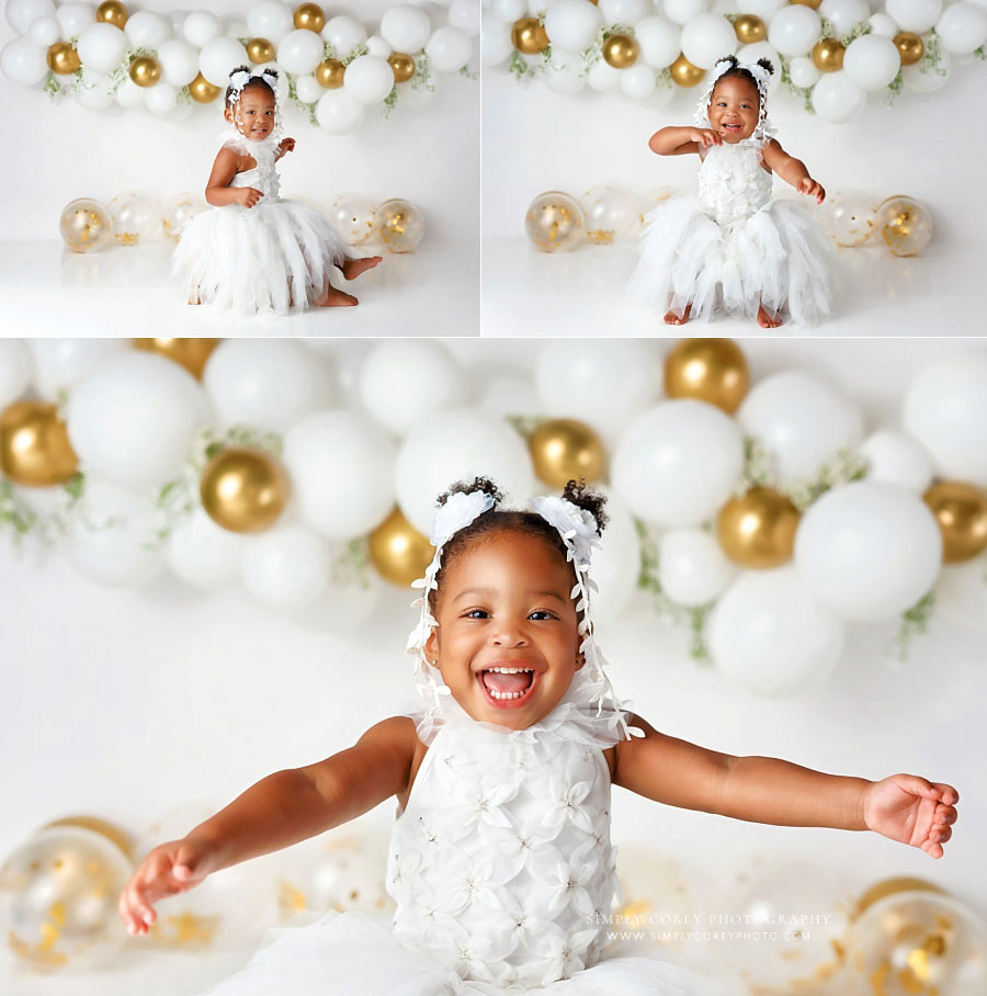baby photographer near Villa Rica, girl with big smile on gold and white studio set