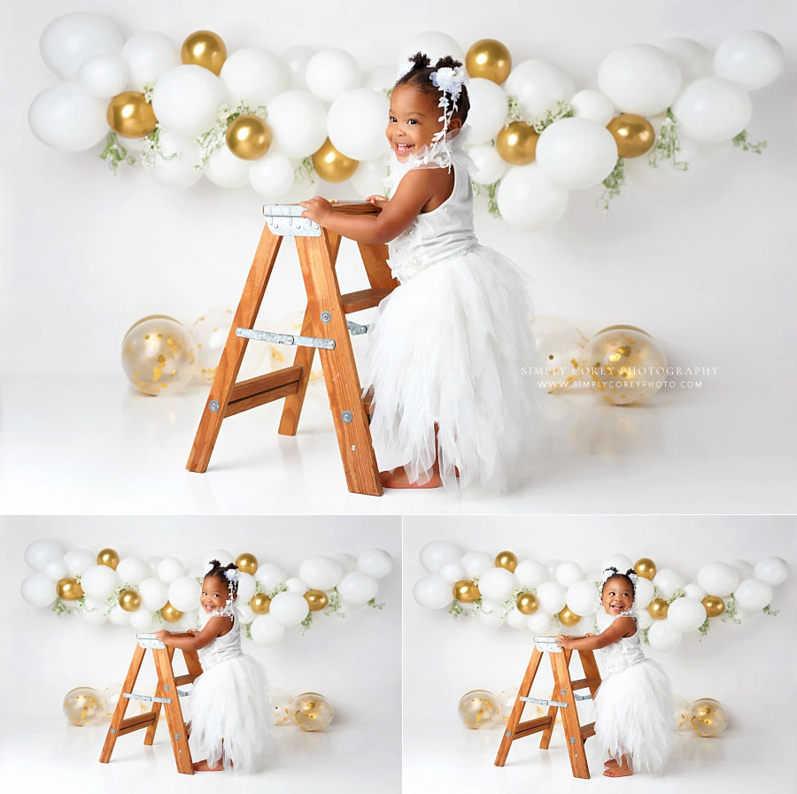 Villa Rica baby photographer, girl with ladder during white and gold studio milestone session