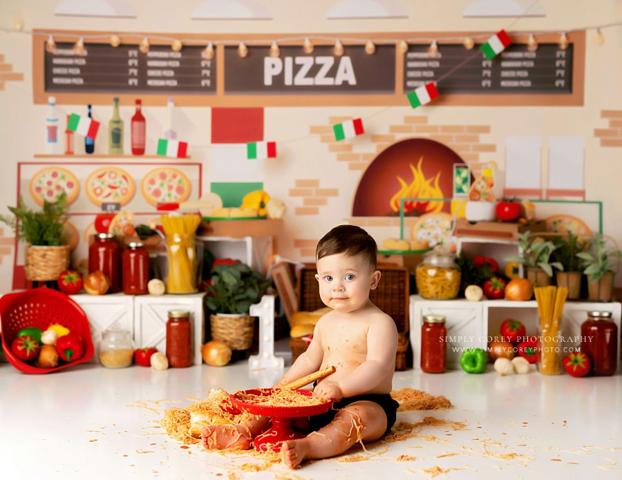 Villa Rica baby photographer, boy making mess with spaghetti n studio milestone set