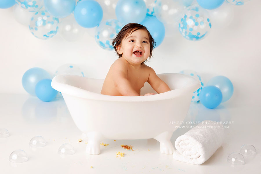 Newnan baby photographer, boy smiling in bath splash after cake smash in studio