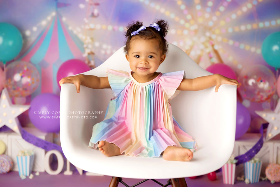 Atlanta baby photographer, girl in chair on pink circus studio set