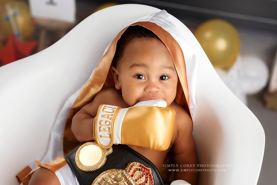 baby photographer near Carrollton, GA; boy in chair with gold boxing gloves