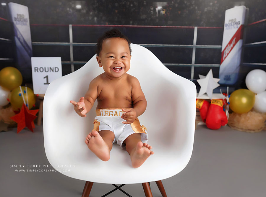 Newnan baby photographer, boy laughing on chair on boxing studio milestone set