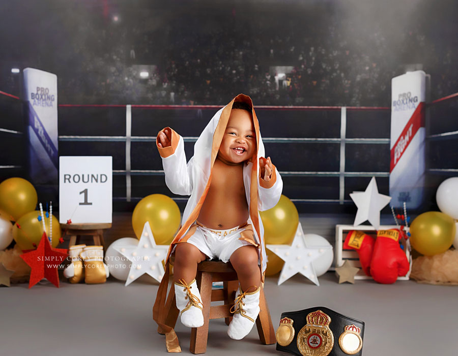 Tyrone baby photographer, boy smiling in boxing robe and shorts on studio milestone set