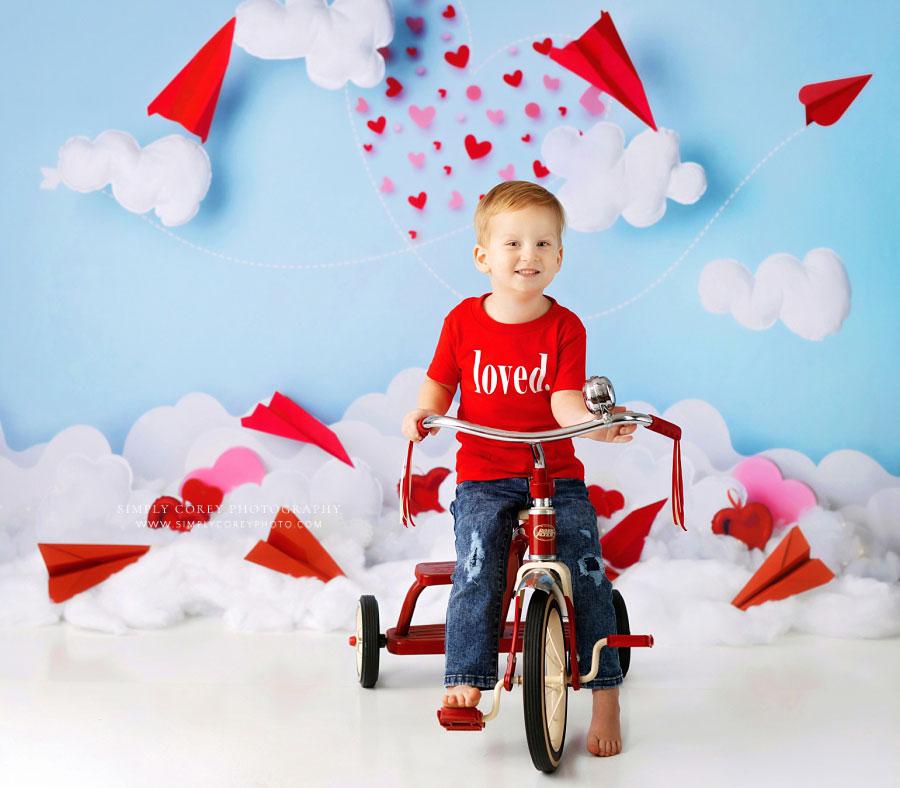 Carrollton baby photographer in Georgia, boy on tricycle for Valentine's studio set