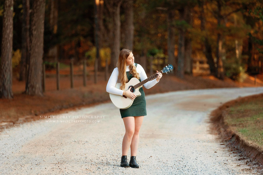 Newnan senior portrait photographer, teen girl in green outside on dirt road with guitar