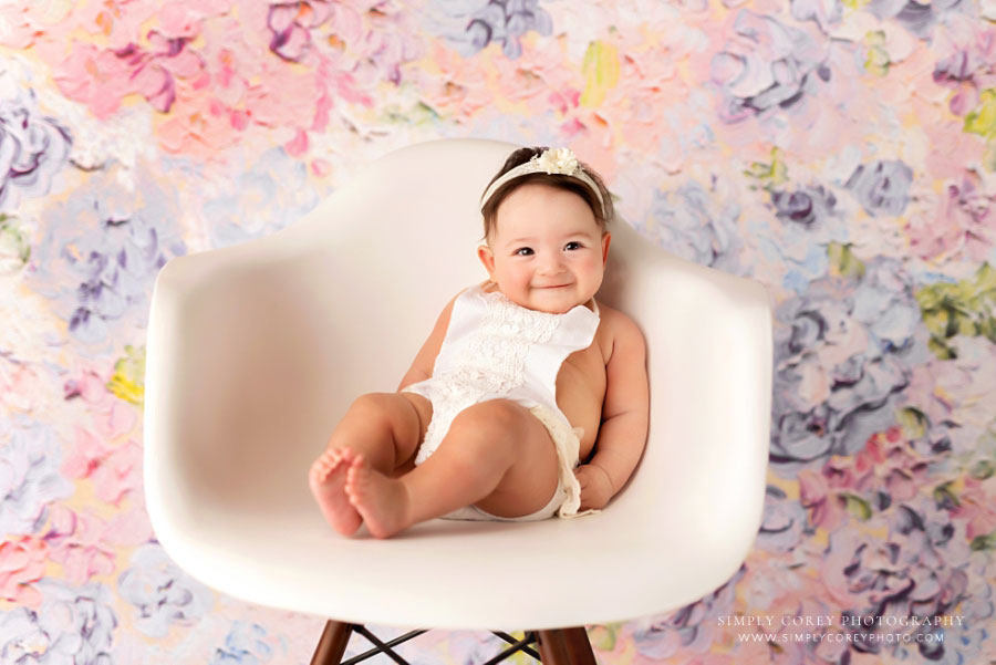 Douglasville baby photographer, girl in chair on floral backdrop in studio