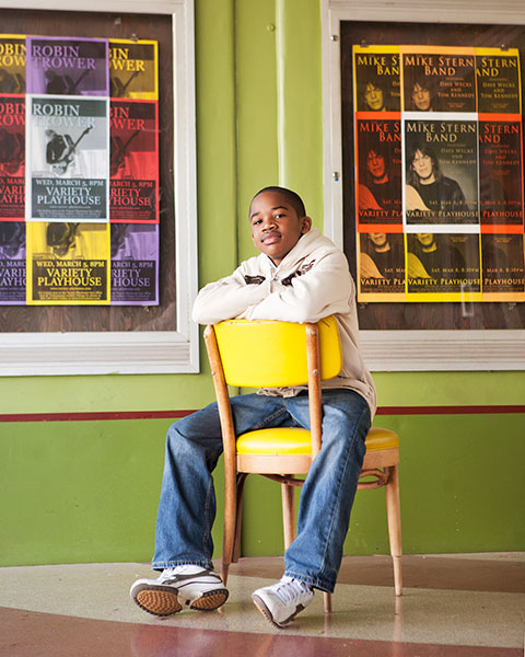 Atlanta children's photographer, teen boy on chair in Little Five Points