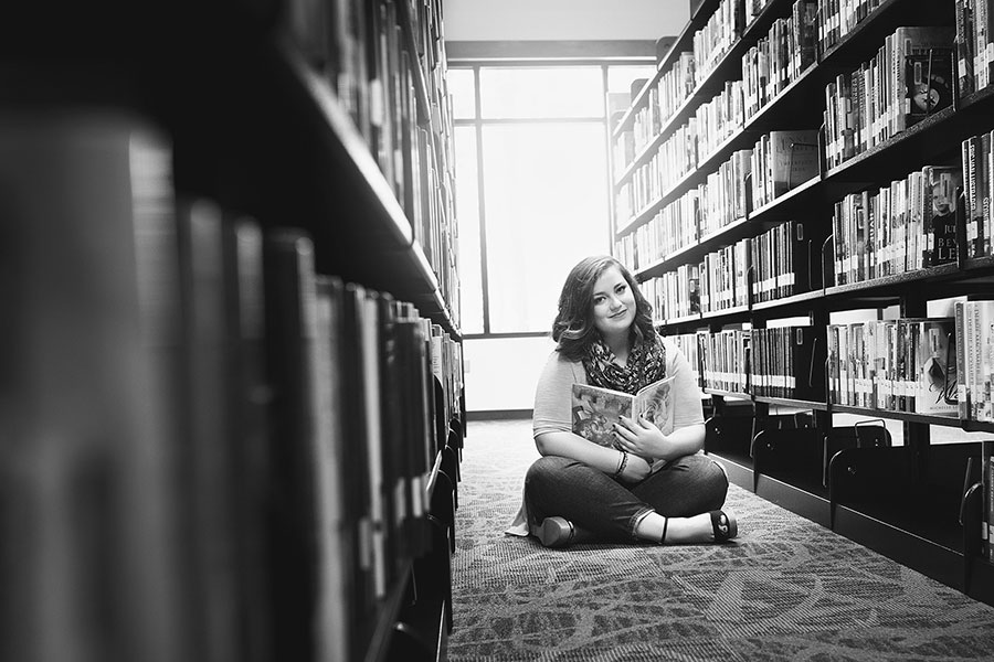 Carrollton senior portrait photographer in Georgia, teen with books in library