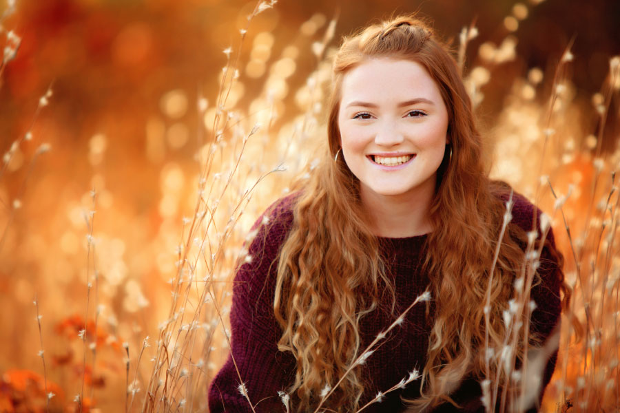Carrollton senior portrait photographer in Georgia, teen in tall grass in fall