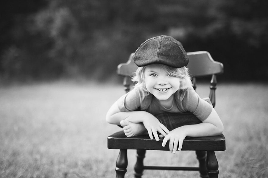 Douglasville kids' photographer, boy outside on chair in black and white