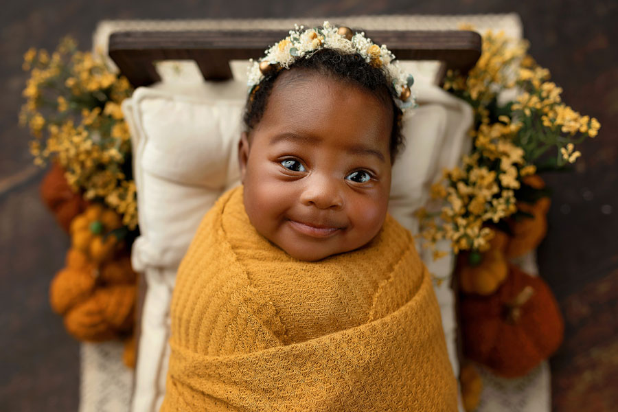 Douglasville newborn photographer, baby girl smiling with fall set