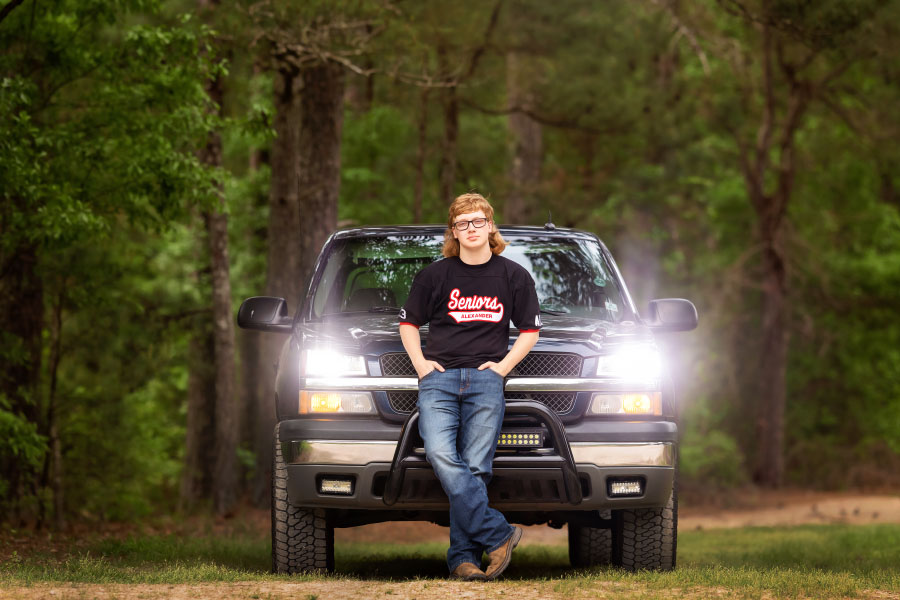 Douglasville senior portrait photographer, teen by truck with headlights on