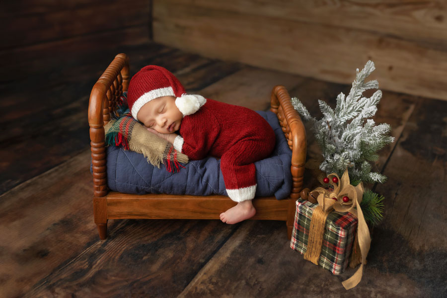 newborn photographer near Atlanta, baby boy in Christmas studio set with bed