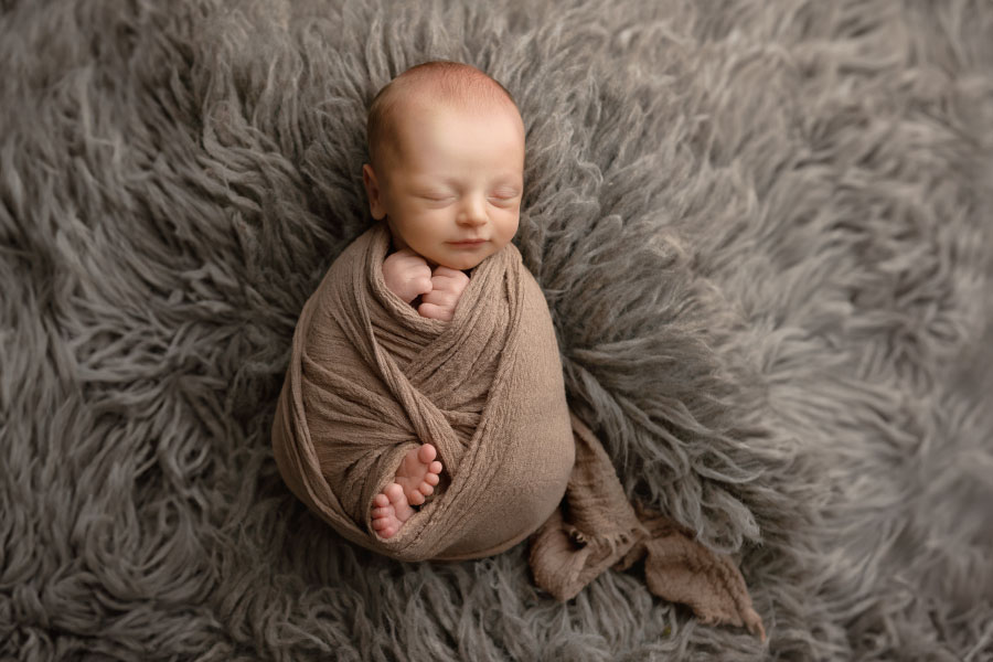 newborn photographer near Douglasville, baby boy in brown swaddle with flokati fur