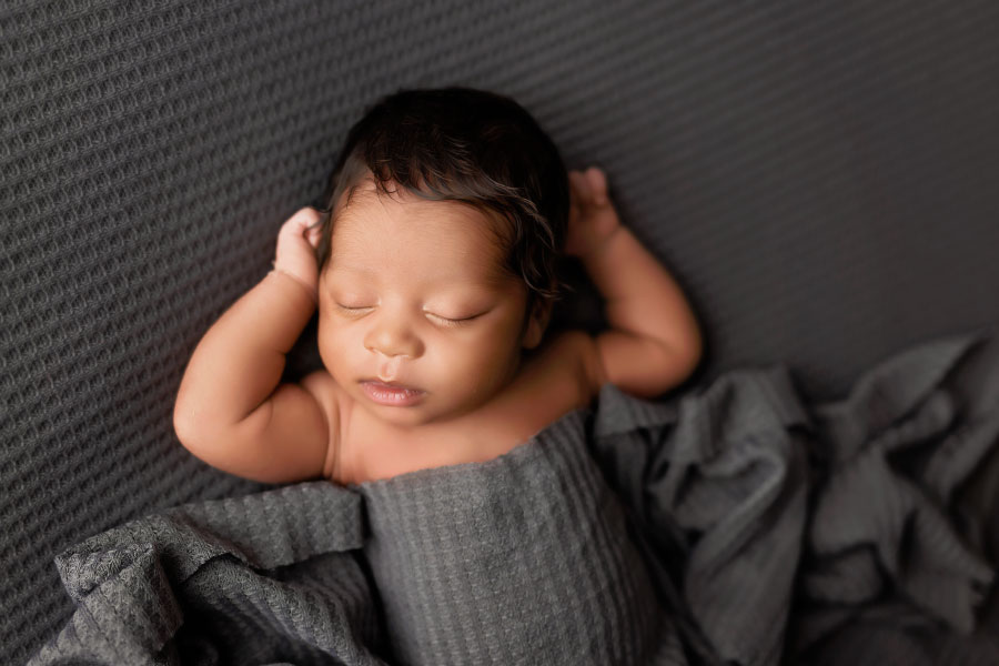 newborn photographer near Douglasville, baby boy in relaxed pose with grey swaddle